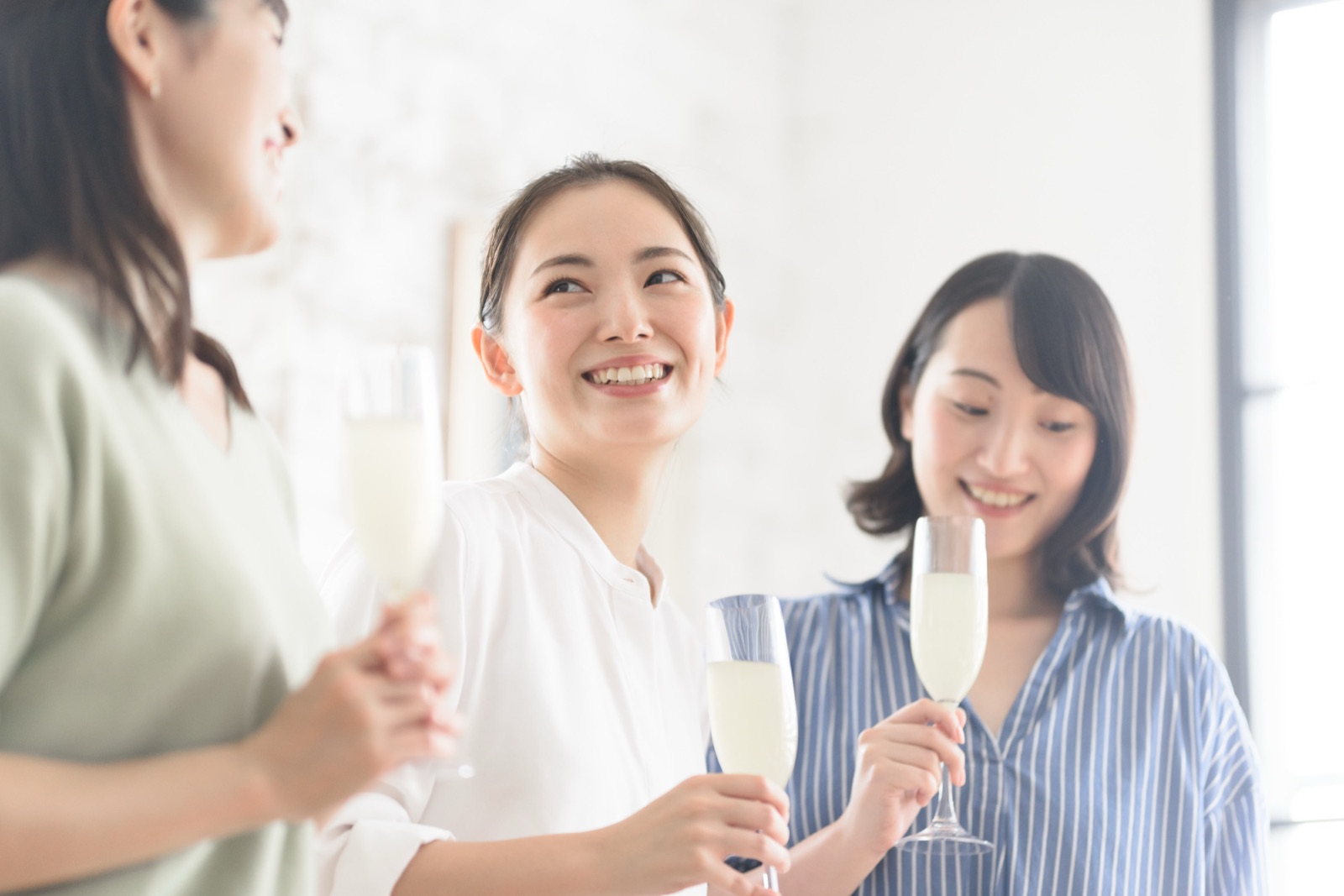 グラスを手に笑顔で語らう3人の女性